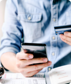 Person making an online payment using smartphone and credit card—illustrating secure digital transactions through AI-powered unified healthcare payment module.